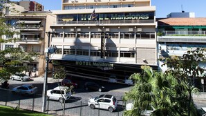 Un hotel de varios pisos con un patio central, rodeado por otros edificios.