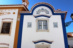 A building with a blue and white facade, a decorative archway with the inscription "Casa da Lua," and a window with a grid pattern. - Villa Ana Margarida Residences (Mafra)