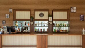 Una zona de bar con paneles de madera, un reloj y estantes llenos de botellas de licores.