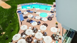 A rooftop pool area with multiple sun loungers and umbrellas, surrounded by a landscaped garden and a view of the ocean. - Mh Peniche, Peniche, Portugal (Peniche)