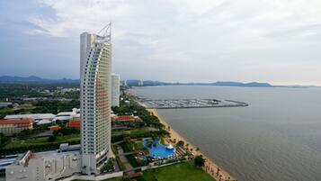 A high-rise hotel with a modern design, a marina, and a beach.