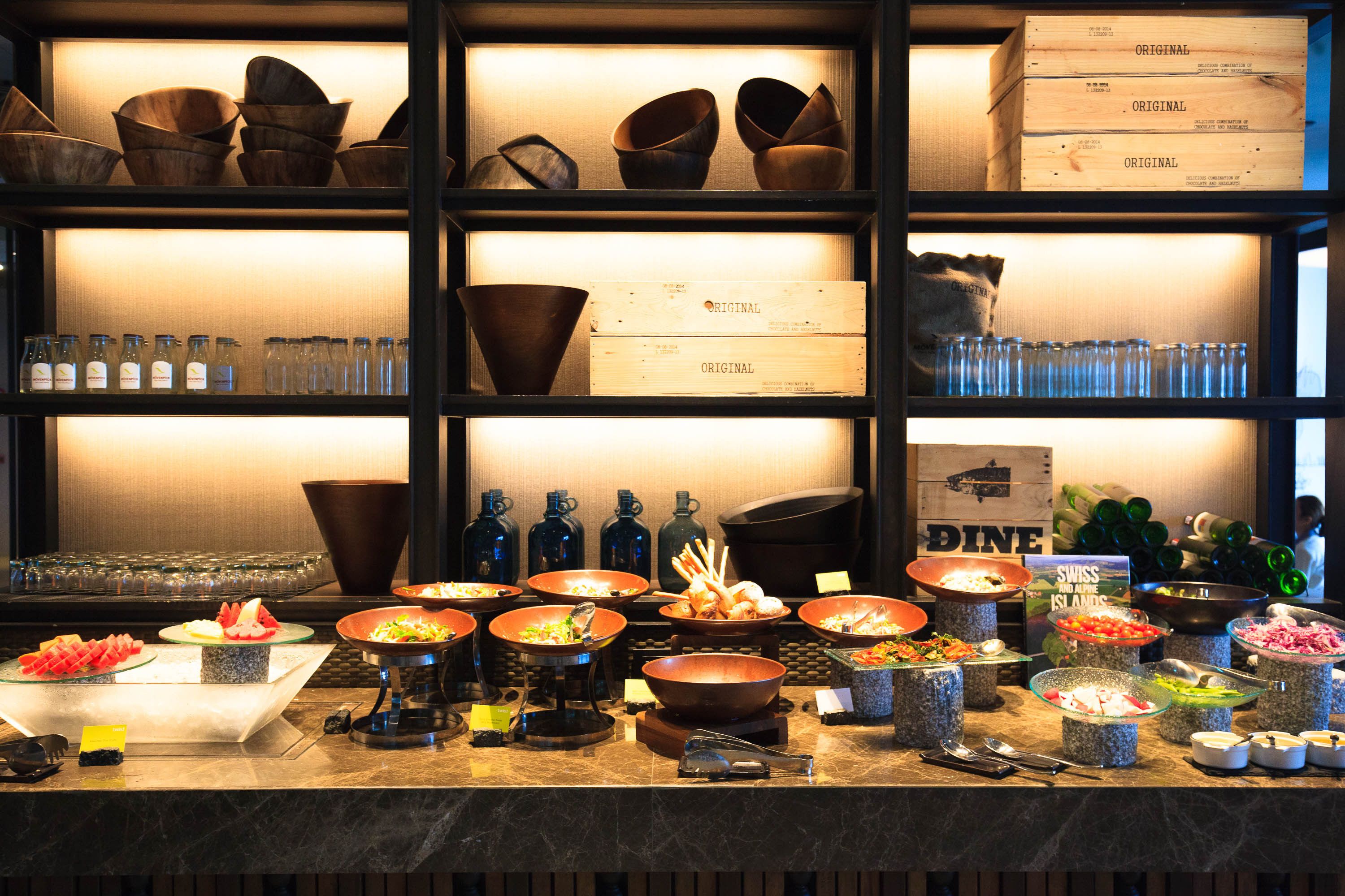 A buffet with various food items and a selection of glassware.