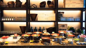 A buffet with various food items and a selection of glassware.