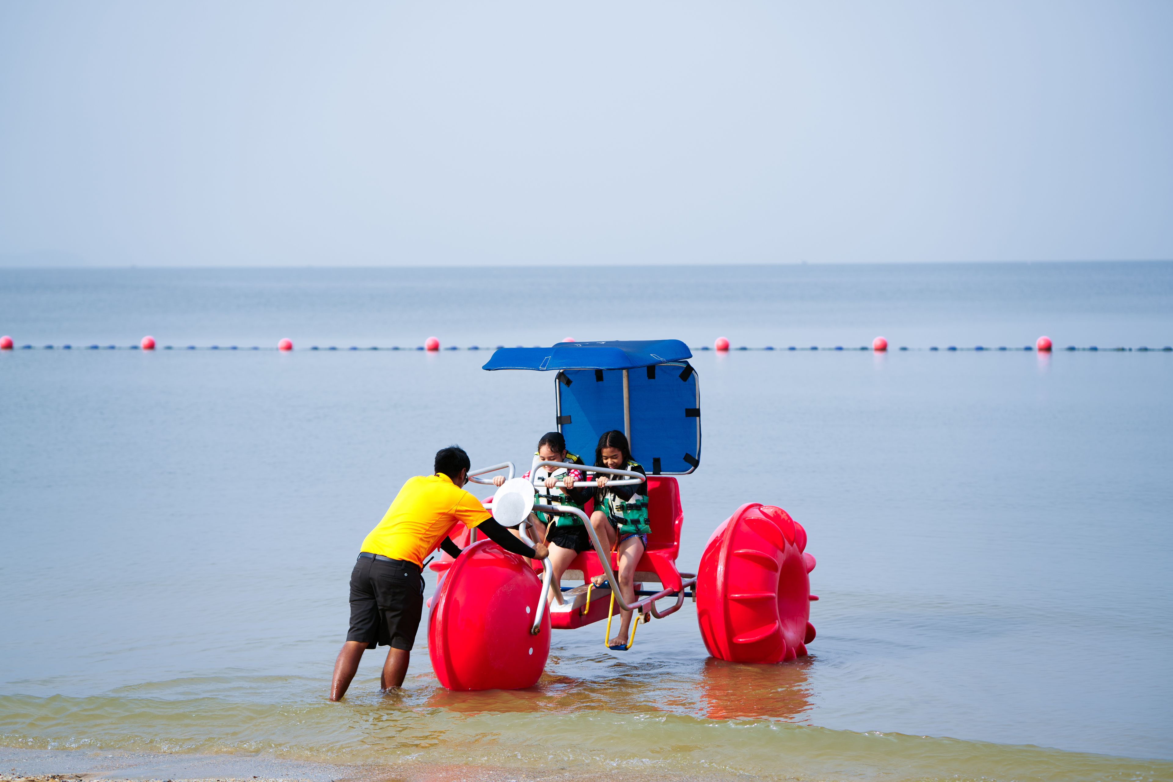 Une scène de plage avec une attraction en forme de roue à eau.