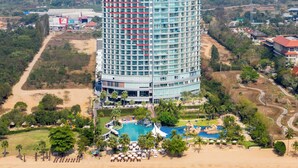 A high-rise hotel with a pool and beachside amenities. - Mövenpick Siam Hotel Na Jomtien Pattaya (Sattahip)
