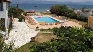 Zona de piscina con sillones de descanso y vistas al mar.
