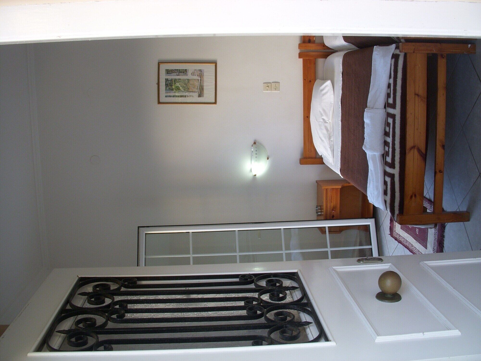 Une cuisine équipée d’une cuisinière à gaz, d’un petit meuble en bois et d’un tableau encadré accroché au mur.