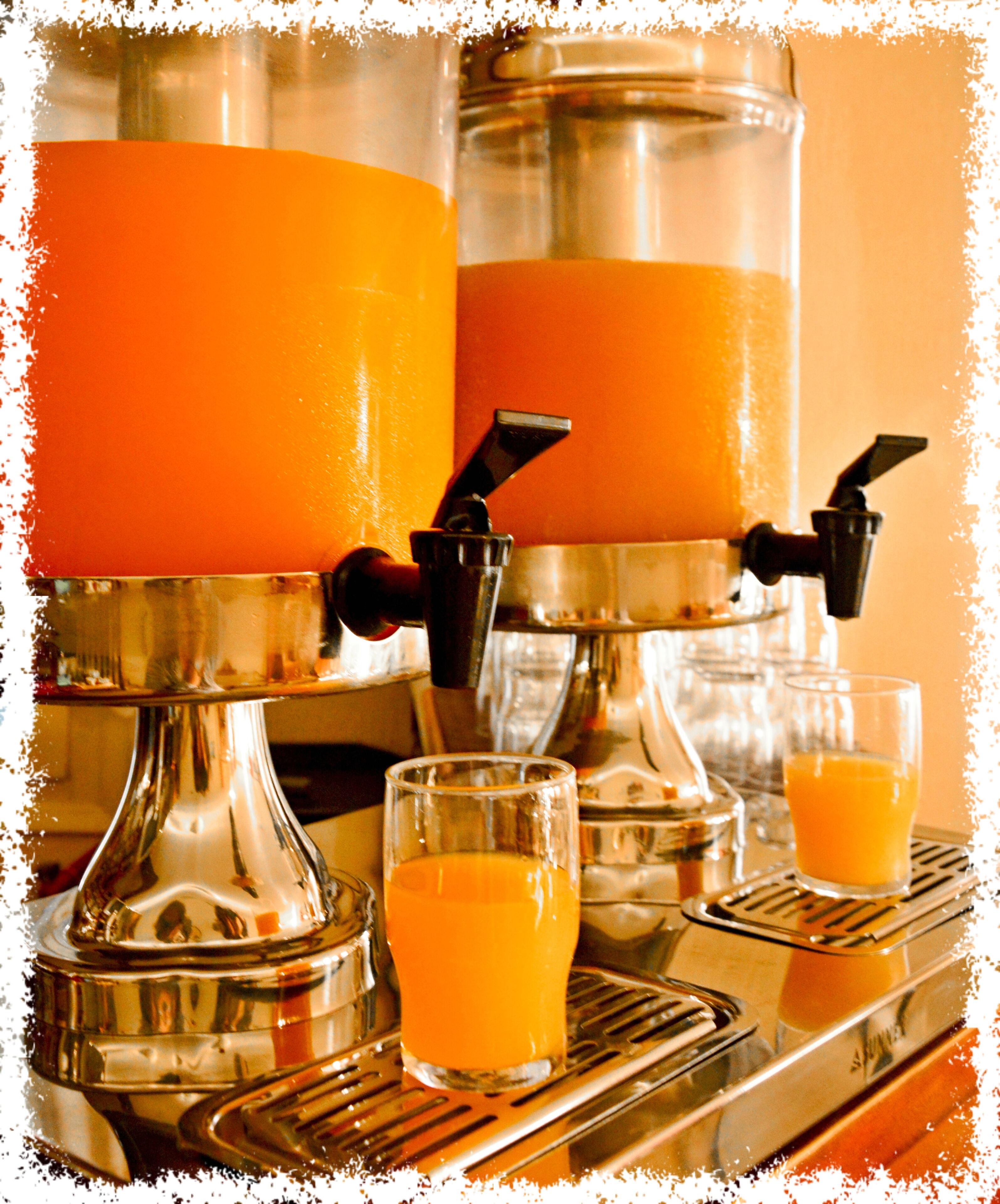 A coffee machine dispensing orange juice into glasses.