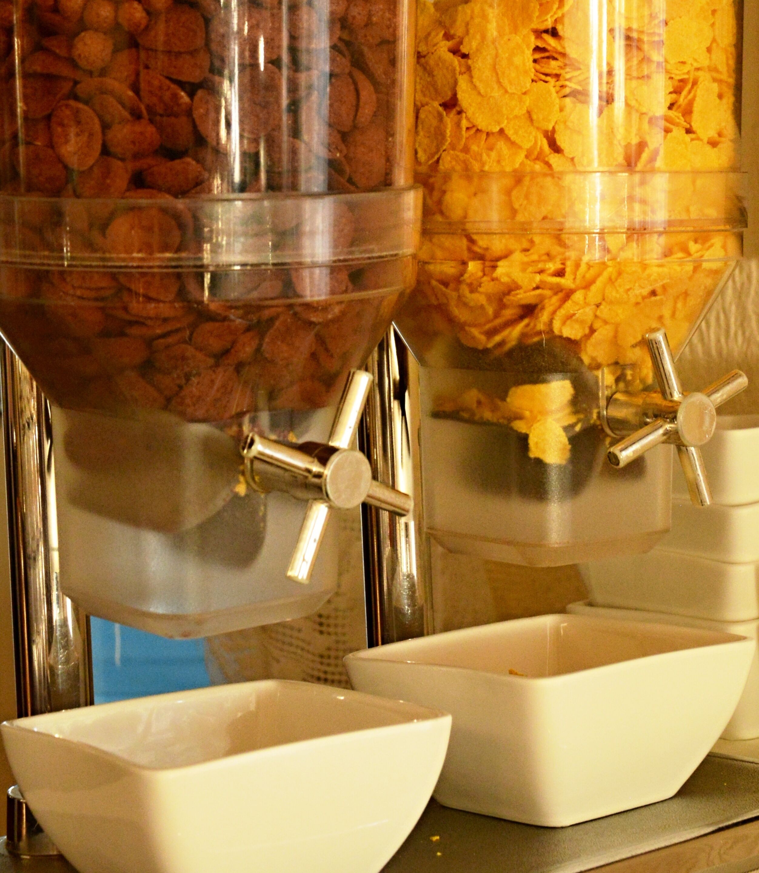 A food dispensing station with two containers, one for nuts and one for cereal flakes.