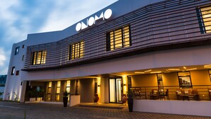 A modern hotel with a prominent "ONOMO" sign, a covered entrance, and a paved driveway. - Onomo Hotel Lome (Lomé)