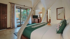 A bedroom with a bed, a television, and a view of the outdoors. - Parigata Villas Resort (Denpasar)