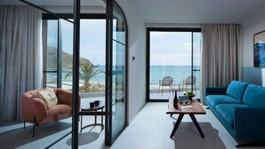 Una sala de estar moderna con un sofá, un sillón, una mesa de centro y vistas al océano.