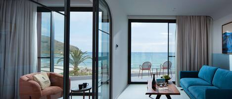 A modern living room with a sofa, a chair, a coffee table, and a view of the ocean.