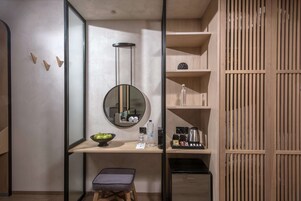 Un baño moderno con espejo, lavamanos y estantes.