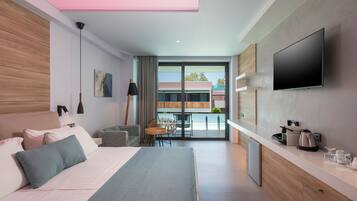 Una habitación de hotel moderna con una cama, un escritorio, un televisor y vistas al exterior.