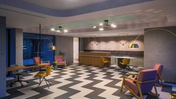 A modern interior with a checkered floor, a reception desk, seating areas, and pendant lighting.