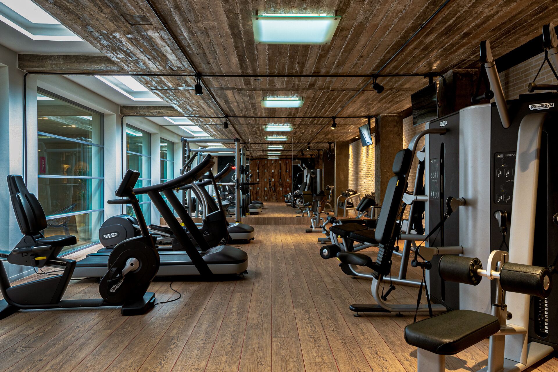 A gym with treadmills, elliptical machines, and weight machines.