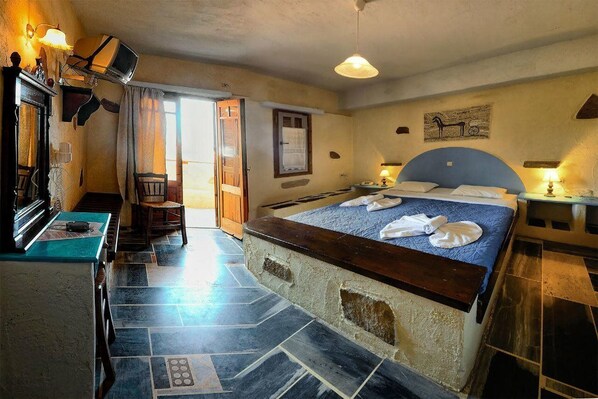 Une chambre à coucher avec un lit, un bureau, une chaise et une fenêtre.