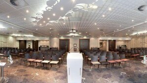 A conference room with rows of chairs, a podium, and a carpeted floor. - Hôtel Mercure Marseille Centre Vieux-Port (MARSEILLE)