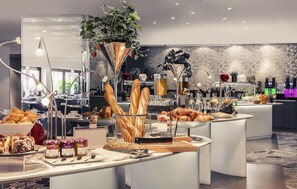 A buffet setup with various food items and a modern interior design. - Hôtel Mercure Marseille Centre Vieux-Port (MARSEILLE)