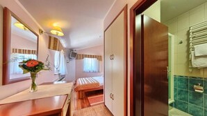 A hotel room with a wooden desk, a bed, a wardrobe, and a bathroom with a towel rack. - Trogir (Trogir)