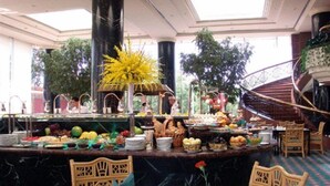 A buffet area with various food items and a decorative centerpiece. - Beijing Grand Hotel (Beijing)