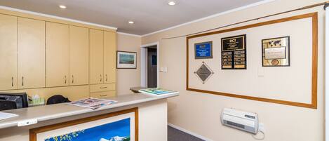 A reception area with a counter, framed artwork, and wall-mounted plaques.