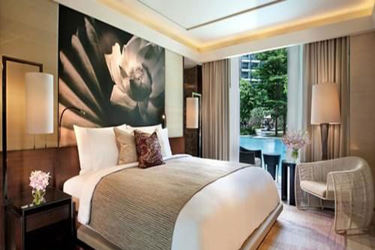 Habitación de hotel con una cama grande, un escritorio, una silla y vistas a zonas verdes.