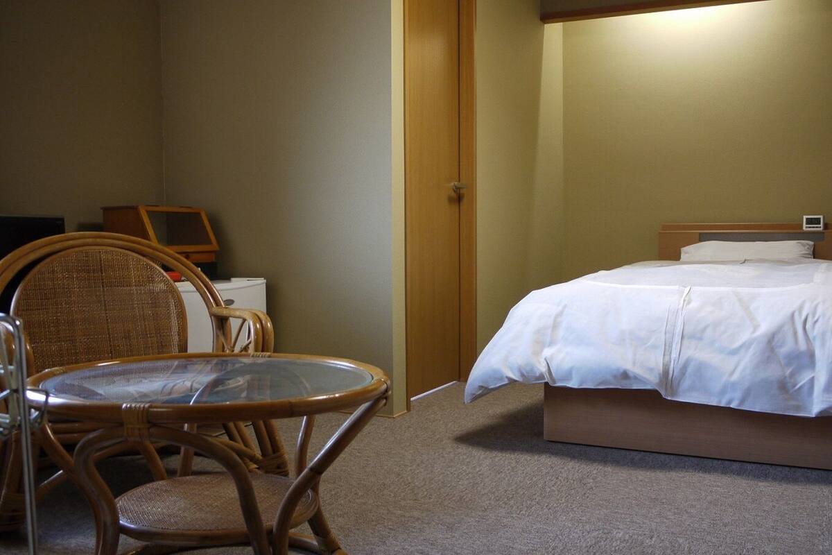 Una habitación de hotel con cama, una silla, una mesa y un escritorio.