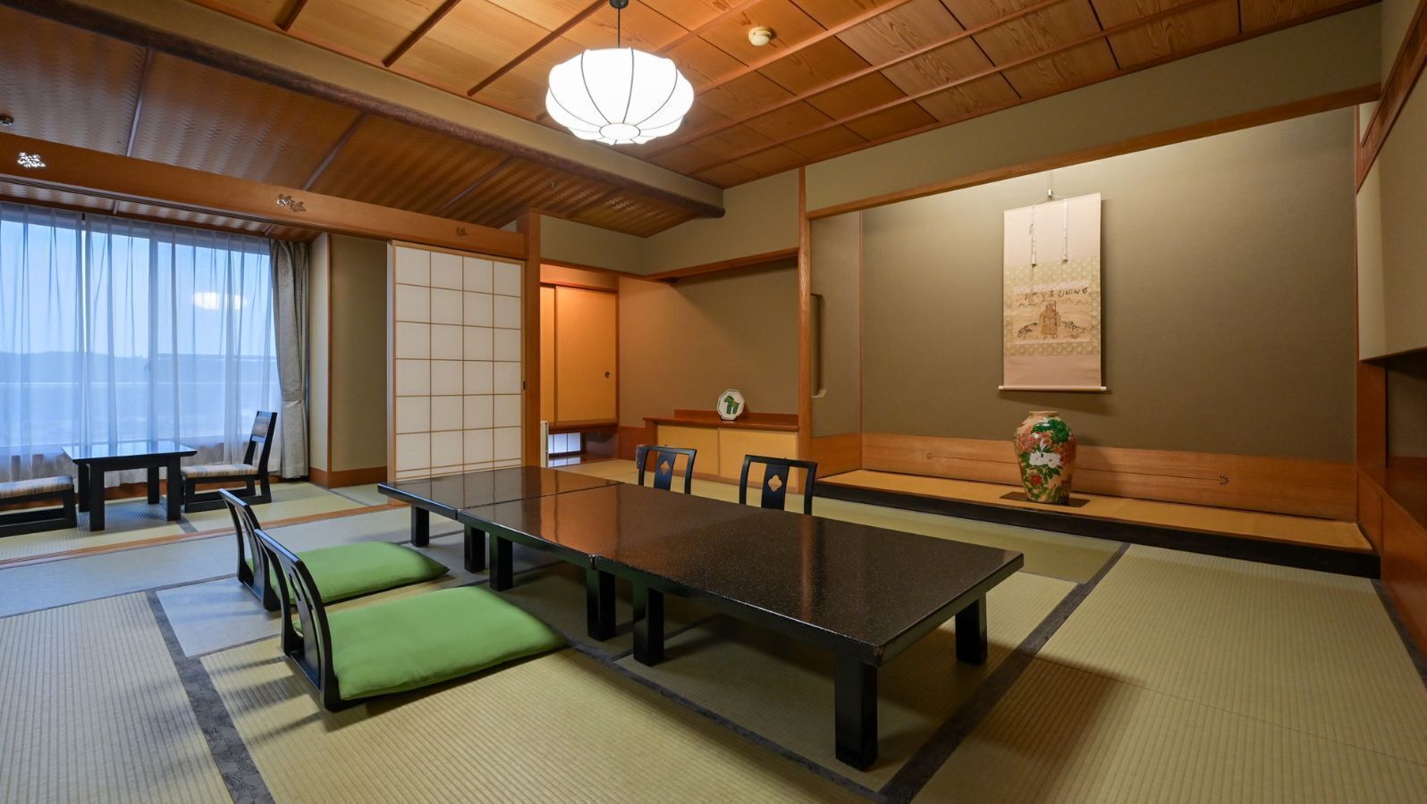 A traditional Japanese room with tatami flooring, a low table, and shoji screens.