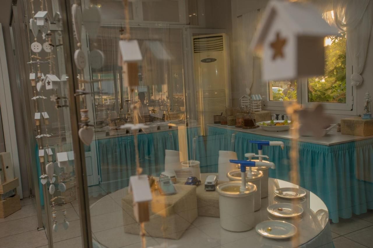 A well-lit room with a glass partition, a teal tablecloth-covered table, and various items on display.
