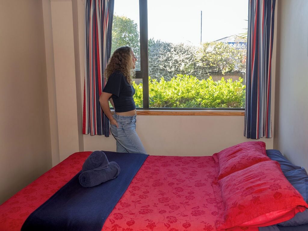 A room with a bed, a window, and curtains.