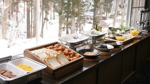 Un buffet proposant une variété d’aliments, notamment du pain, des pâtisseries et des condiments.