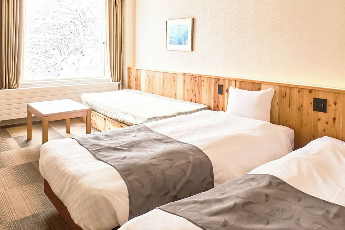 Une chambre d’hôtel avec deux lits, une petite table et une chaise.