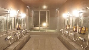 Un espace de douche public équipé de plusieurs pommeaux de douche et de sèche-mains.