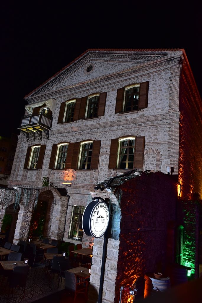 Um edifício de pedra com um relógio, área de estar ao ar livre e uma placa que diz 'STABRETTI'.