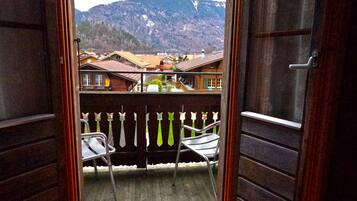 Ein offener Balkon mit Blick auf einen Berg und ein Dorf.