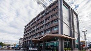 A multi-story hotel with a modern design, featuring a prominent entrance and a parking area in front. - Leosor Hotel (Nakhon Ratchasima)