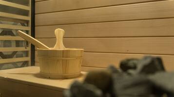 A wooden bucket with a spoon on a wooden surface, possibly in a room with wooden paneling.