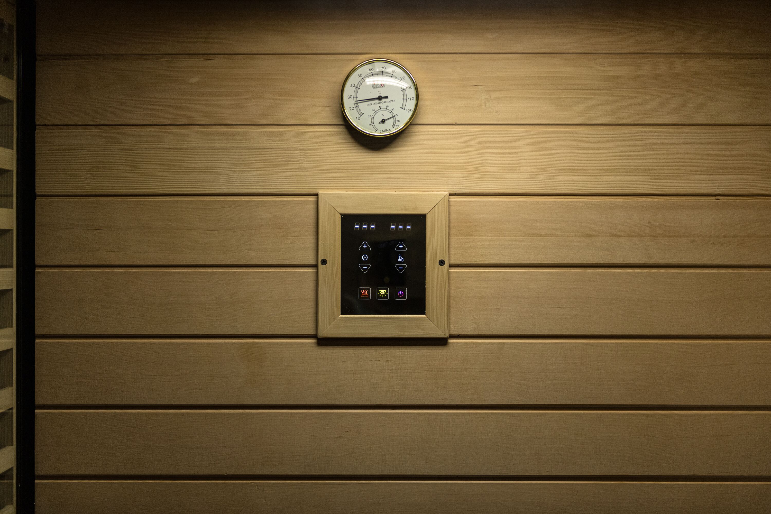 Et panel monteret på væggen med trykmåler og digitalt display med forskellige knapper.