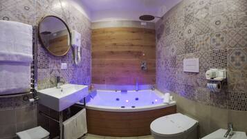 Un bagno moderno con una vasca freestanding, un mobile vanità con specchio e un water.