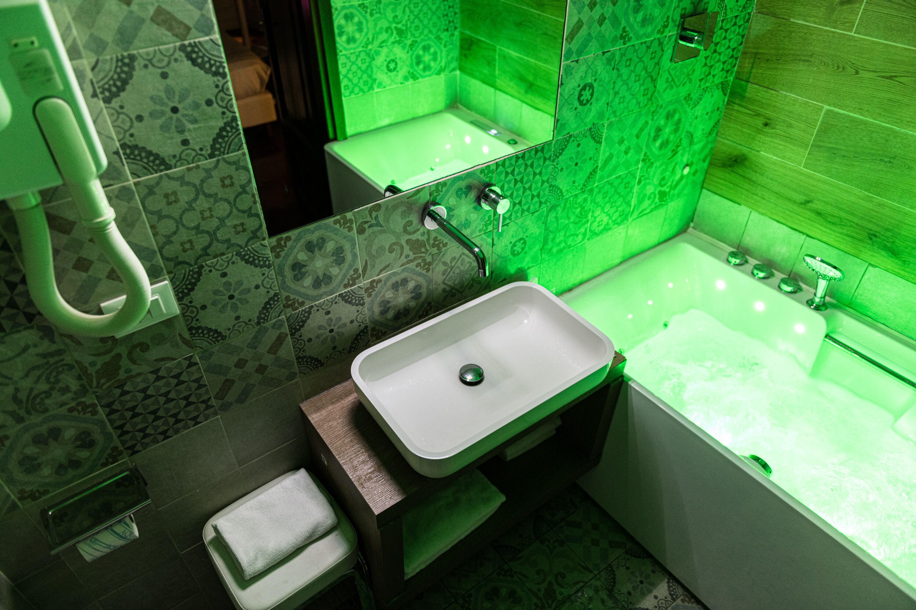 A bathroom with a white sink, a bathtub, and a mirror.