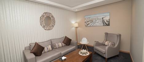 A hotel room with a sofa, armchair, and a coffee table.