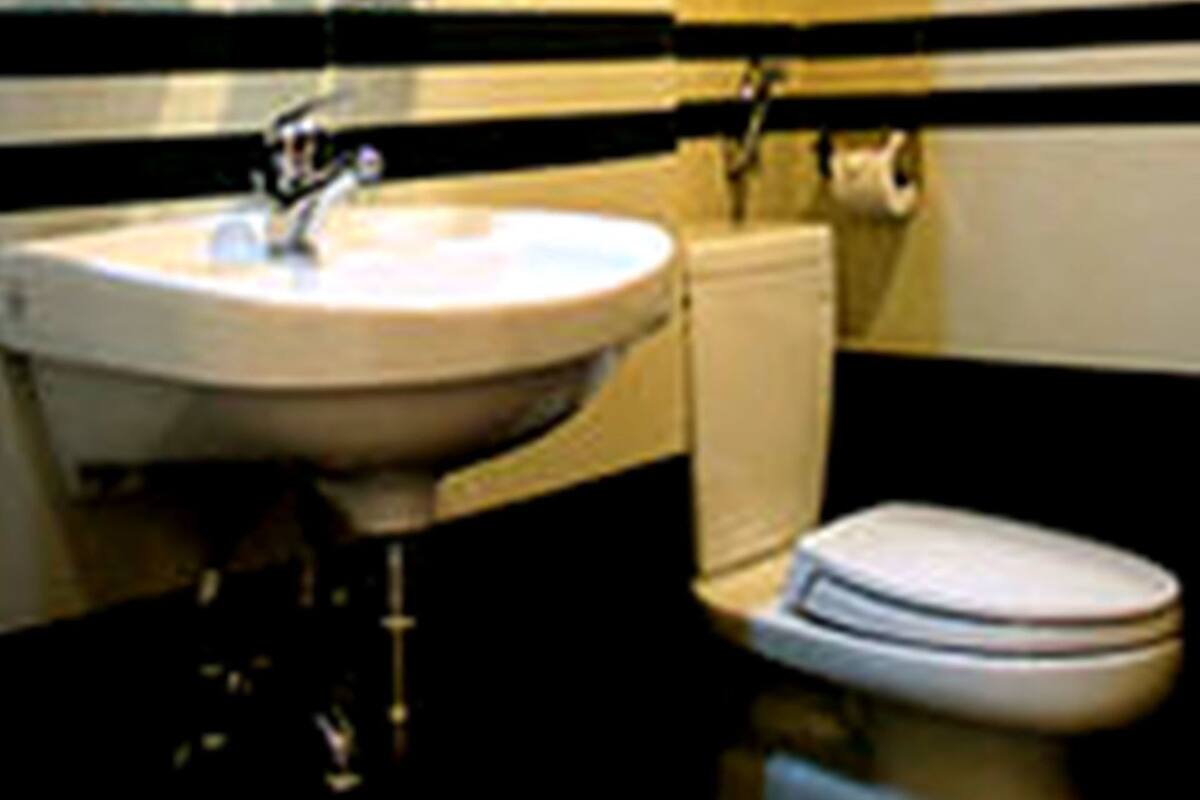 A bathroom with a sink, mirror, and toilet.