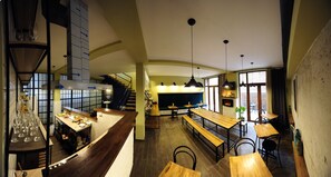 Ein Restaurant mit einer langen Theke, mehreren Sitzbereichen und einer Treppe zu einer erhöhten Ebene.