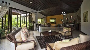 A spacious living area with a high ceiling, a dining area, and a kitchen. - Arenal Springs Resort (La Fortuna)