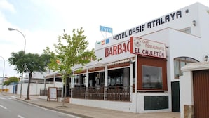 Rakennuksessa on kyltti, jossa lukee »Hotel Oasis Atalaya» ja »Barbacel Chuleton».