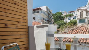 A balcony with a table, two chairs, and a book. - Akti (Skiathos)