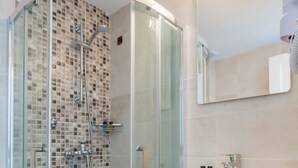 A modern bathroom with a glass-enclosed shower, a white sink, and a tiled backsplash. - Akti (Skiathos)