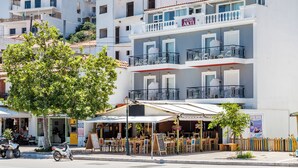 A hotel with balconies, outdoor seating, and a sign indicating it is a hotel. - Akti (Skiathos)